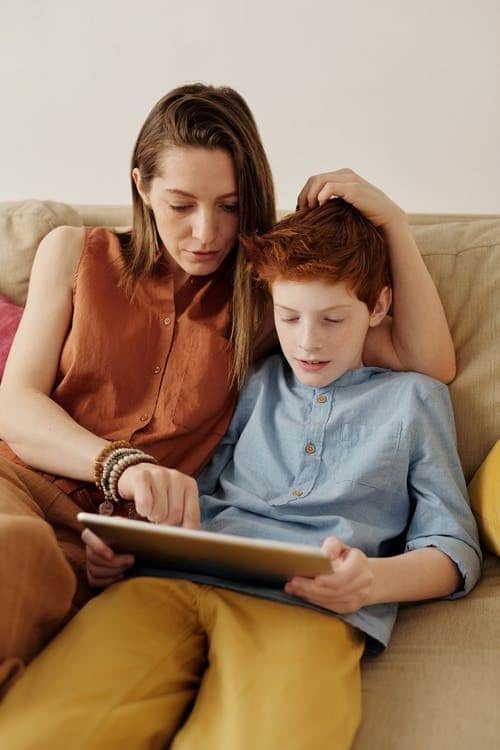 A mother and son sitting and discuss virtual learning progress