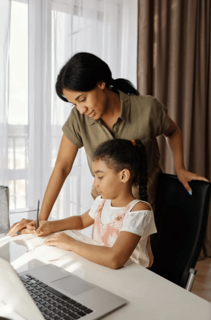 A mother is helping her daughter do her homework from her virtual online school
