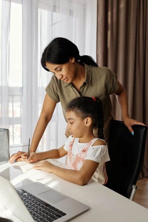 A mother helping her child with online classes