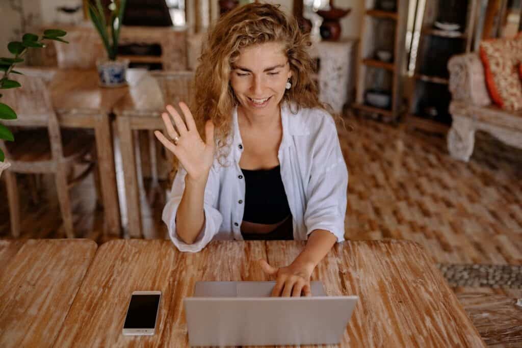 A teacher greeting her students in an online class