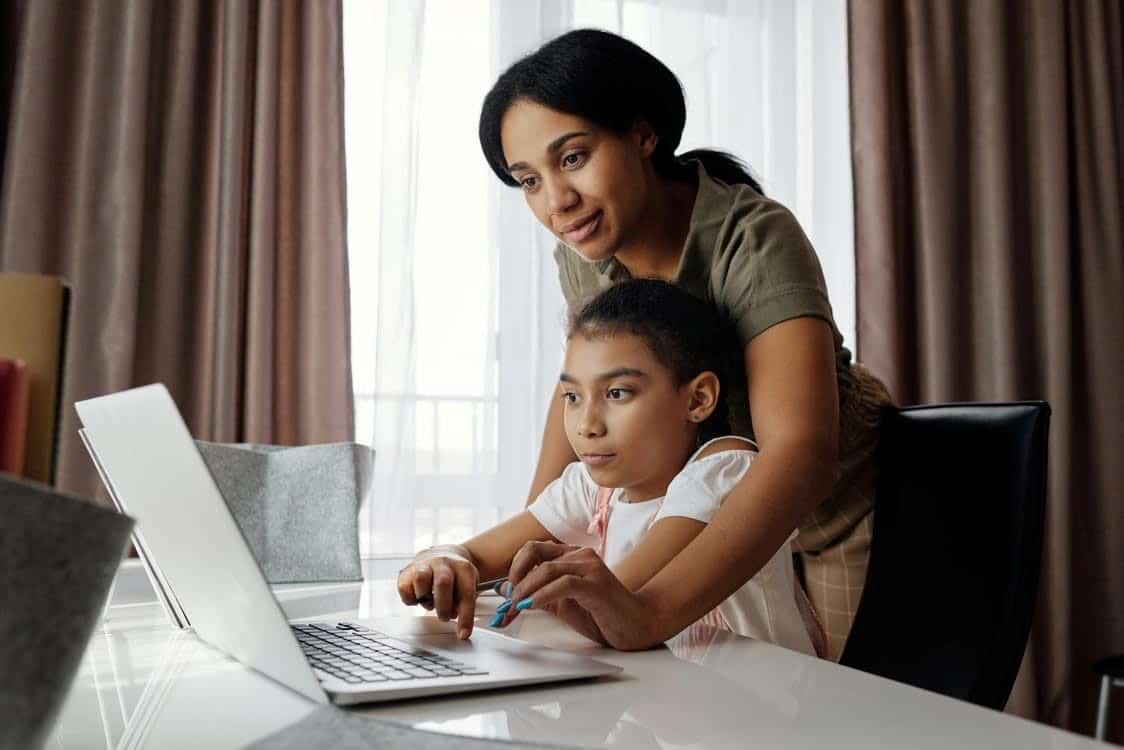 A mother helps her daughter with learning from home
