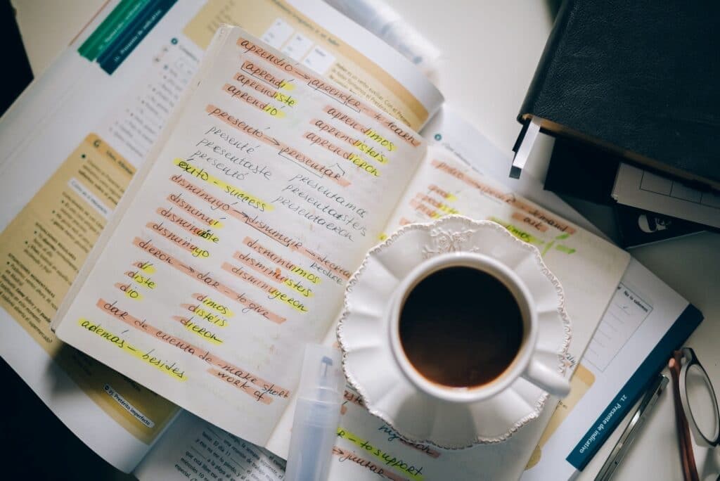 A cup of tea placed on top of foreign language notes