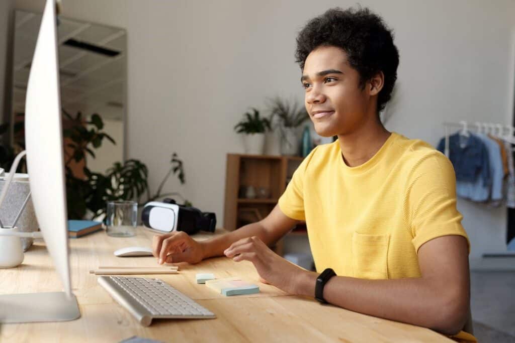 Boy in yellow shirt interacting in an online class.