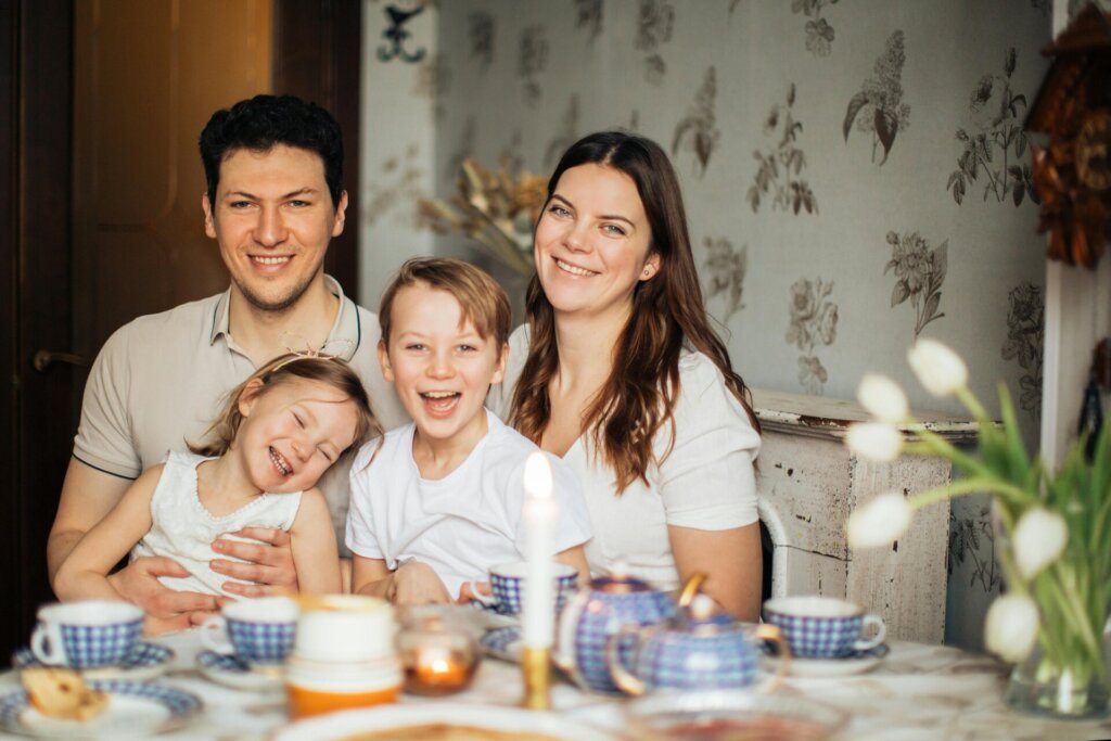 Parent pointing to language flashcards with smiling child at desk