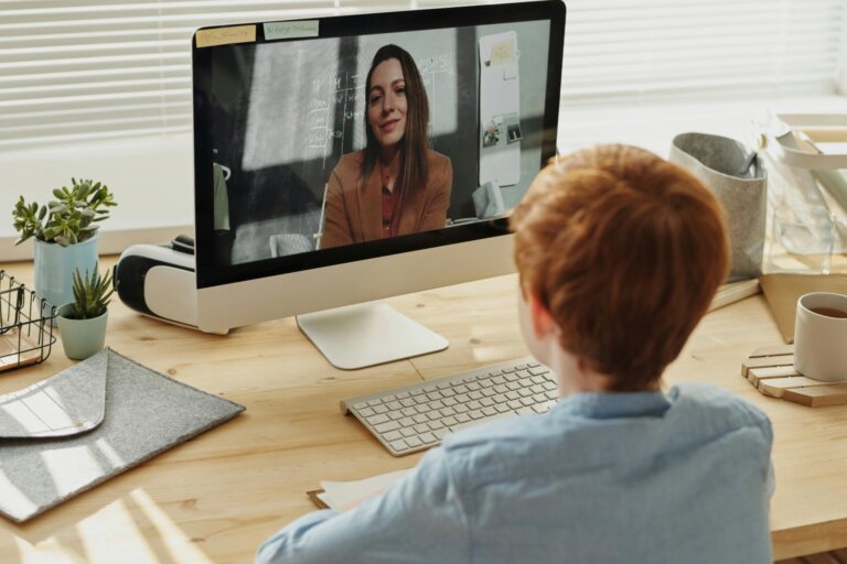 Child in home classroom focused on laptop screen