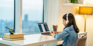 American expat student attending her online bilingual high school class on a laptop.