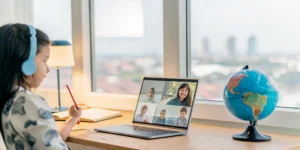 Girl with headphones on a laptop attending the best online school for American children overseas.