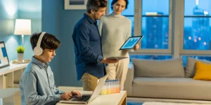 American expat teen studies at an online high school while parents look on.