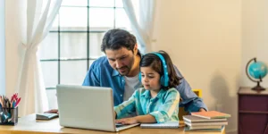American expat father helps his daughter with her online elementary school work.