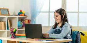 Student learning online from home with laptop and notebooks on desk